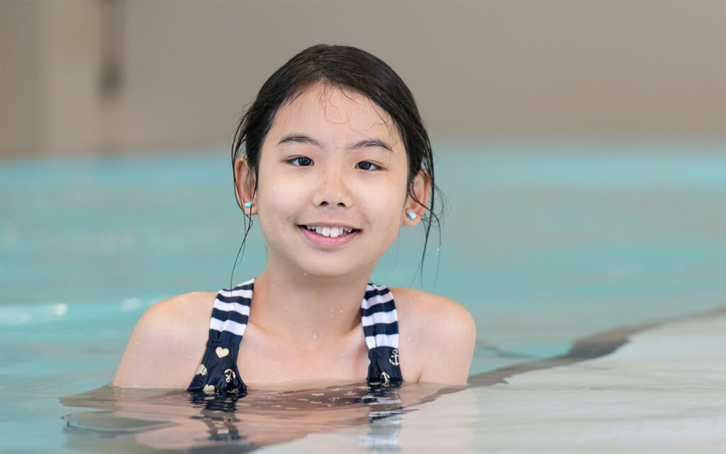 Young girl learning to swim in aquatic therapy