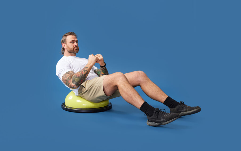 Adult male doing ab crunches on an exercise ball