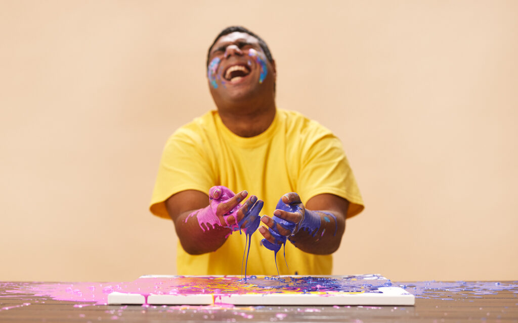 Man laughing during a hands-on paint activity