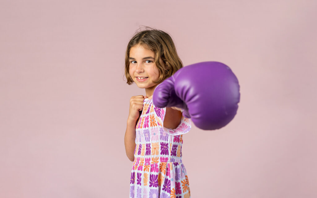 Young female wearing a dress and purple boxing glove
